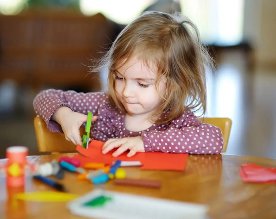 a girl coloring on a paper