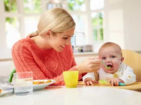 a person feeding a baby