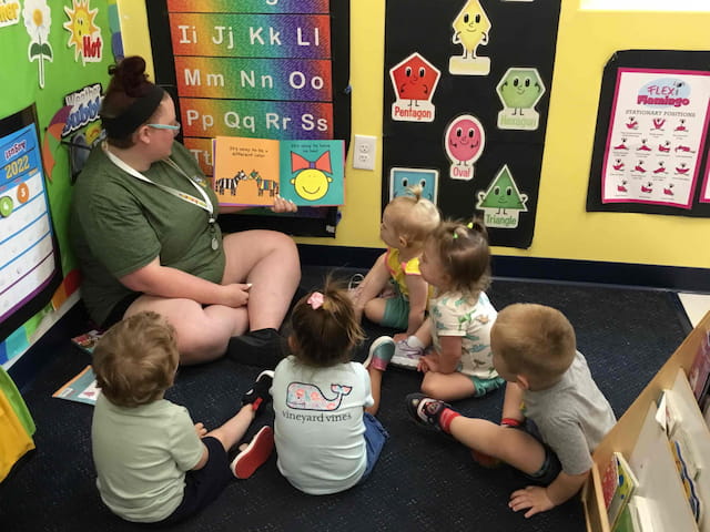 a person reading a book to a group of children