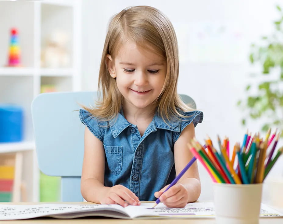 a young girl sitting at a desk