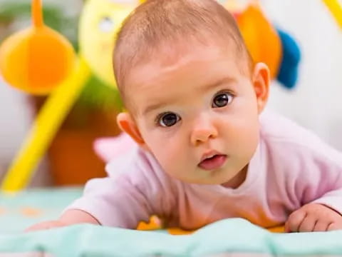 a baby lying on a blanket