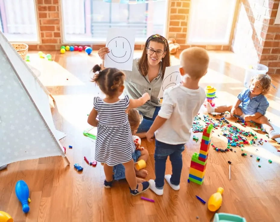 a person and several children playing with toys in a room