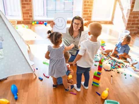 a person and several children playing with toys in a room