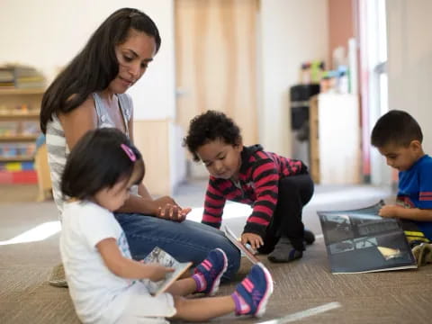 a person and kids looking at a laptop