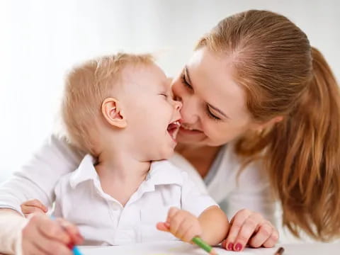 a person kissing a baby