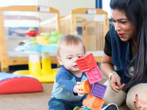 a woman and a baby playing with toys