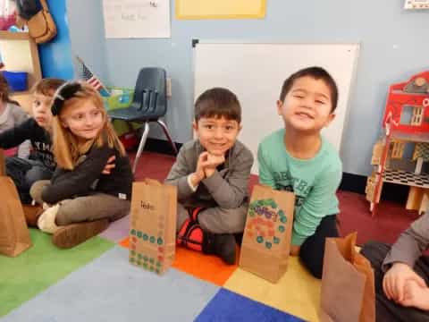 a group of children sitting on the floor with boxes in front of them