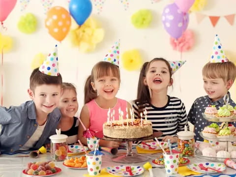 a group of people around a table with a cake