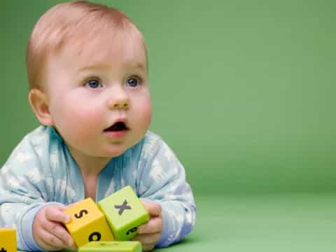 a baby holding a yellow toy