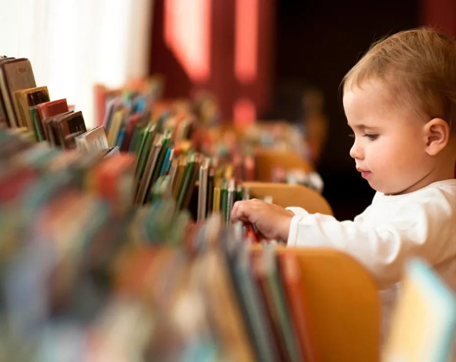 a young boy looking at a bunch of books