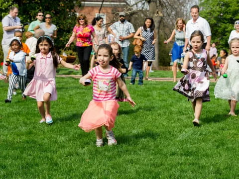 a group of children running on grass