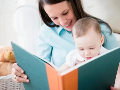 a person and a baby looking at a book