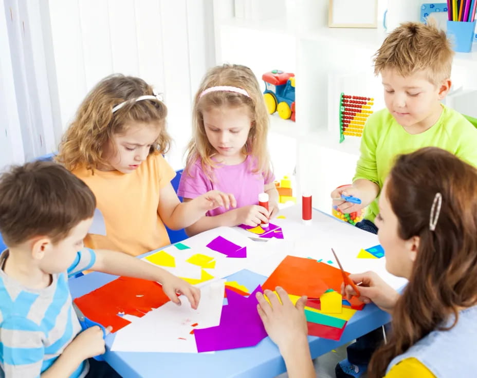 a group of children sitting around a table