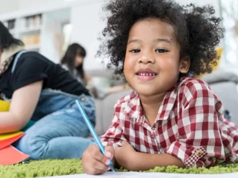 a young boy sitting on the grass