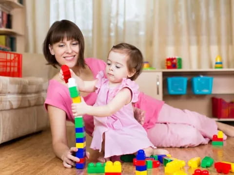 a person and a child playing with toys on the floor