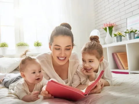 a person and two children sitting on a bed