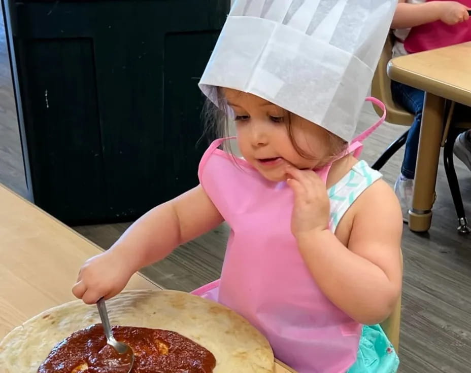 a little girl eating pizza