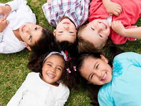 a group of children lying on the ground smiling