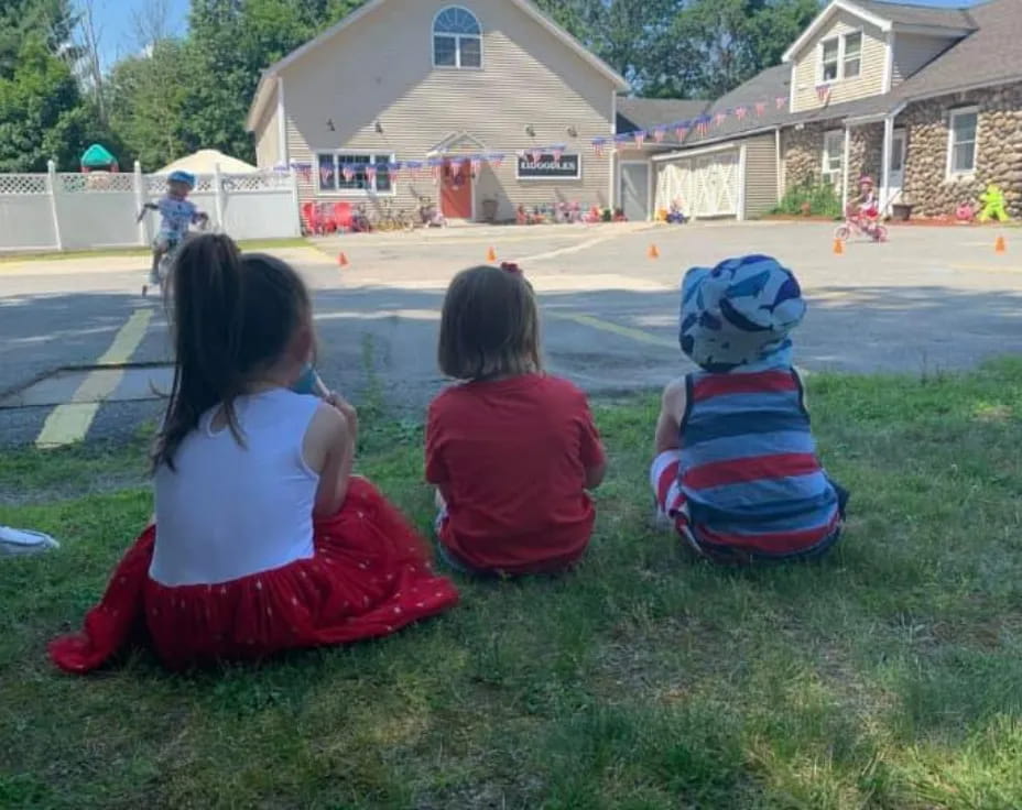 a group of children sitting on the grass