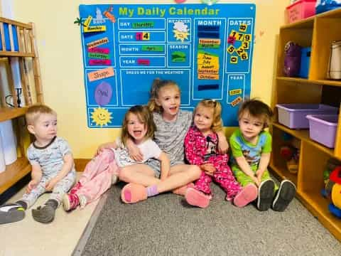 a group of children sitting on the floor in a room