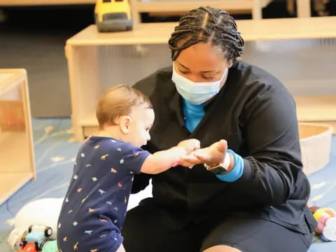 a person in a mask holding a baby