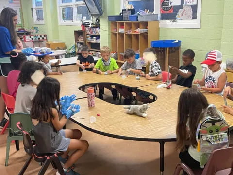 a group of children sitting around a table with a dog