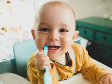 a baby holding a toothbrush