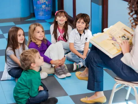 a group of children sitting on the floor reading a book