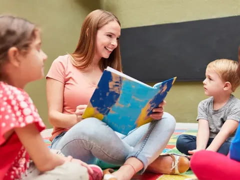 a person reading a book to a group of children