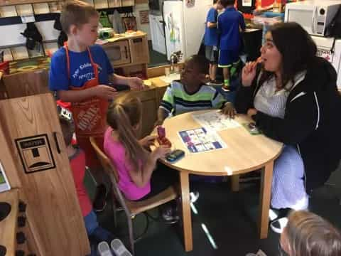 a person and children sitting at a table