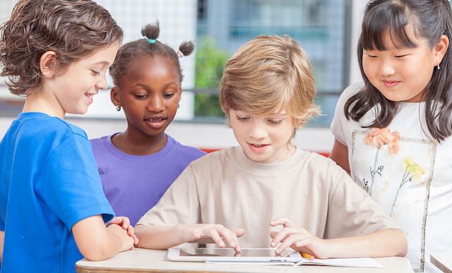 a group of children looking at a tablet