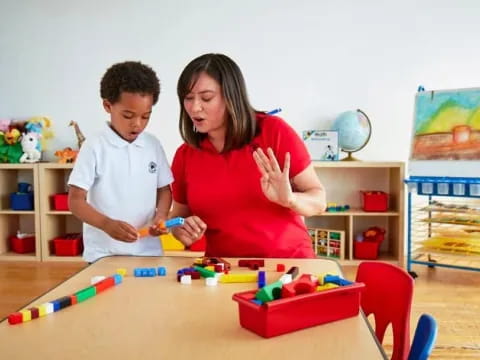 a person and a boy playing with toys in a room