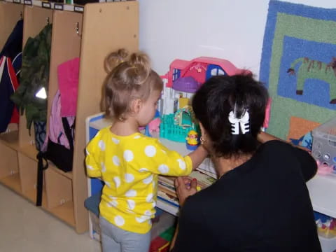 a person and a child in a room with clothes and a closet