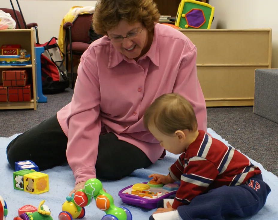 a person and a child playing with toys on the floor