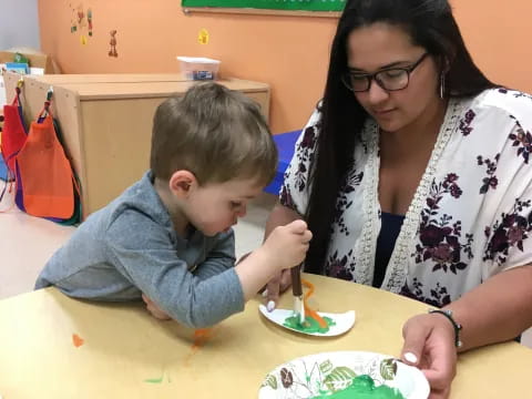 a woman and a child painting