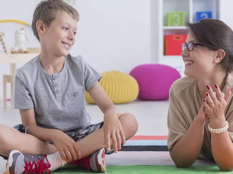 a person and a boy sitting on the floor