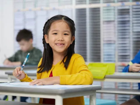 a young girl sitting at a desk