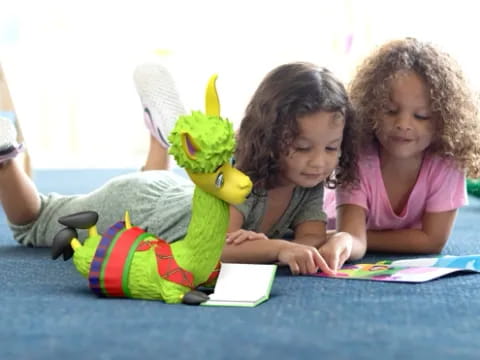 a couple of children sitting on the floor with a stuffed animal