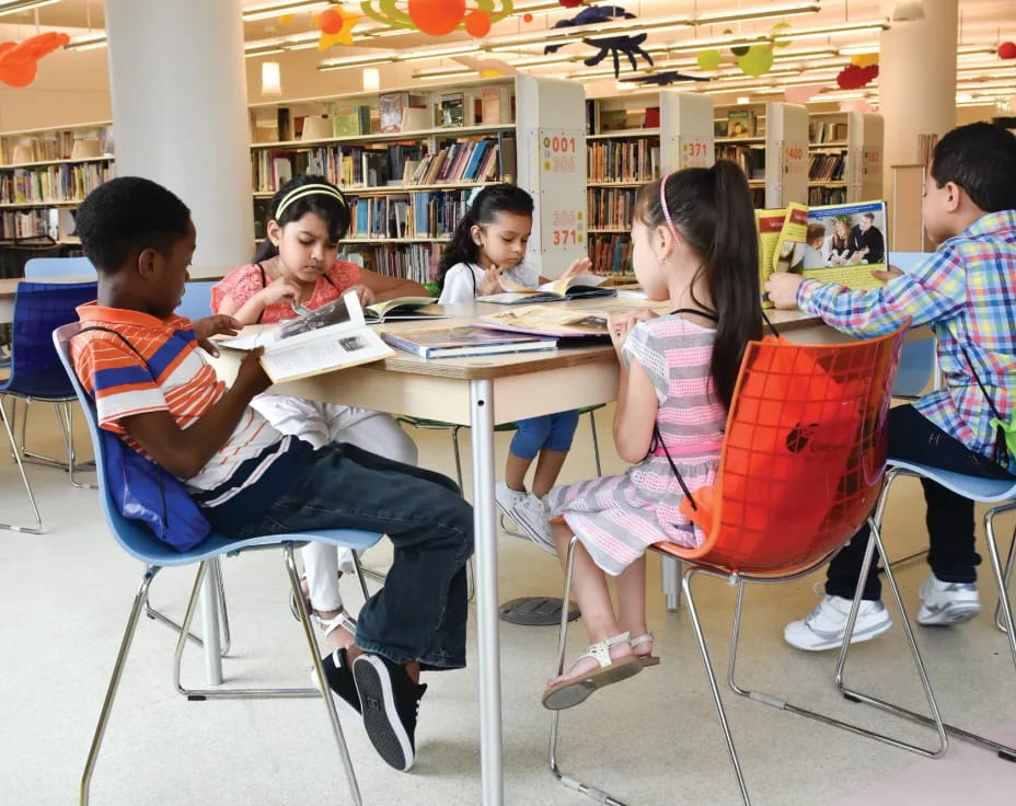 a group of people sitting at a table in a library