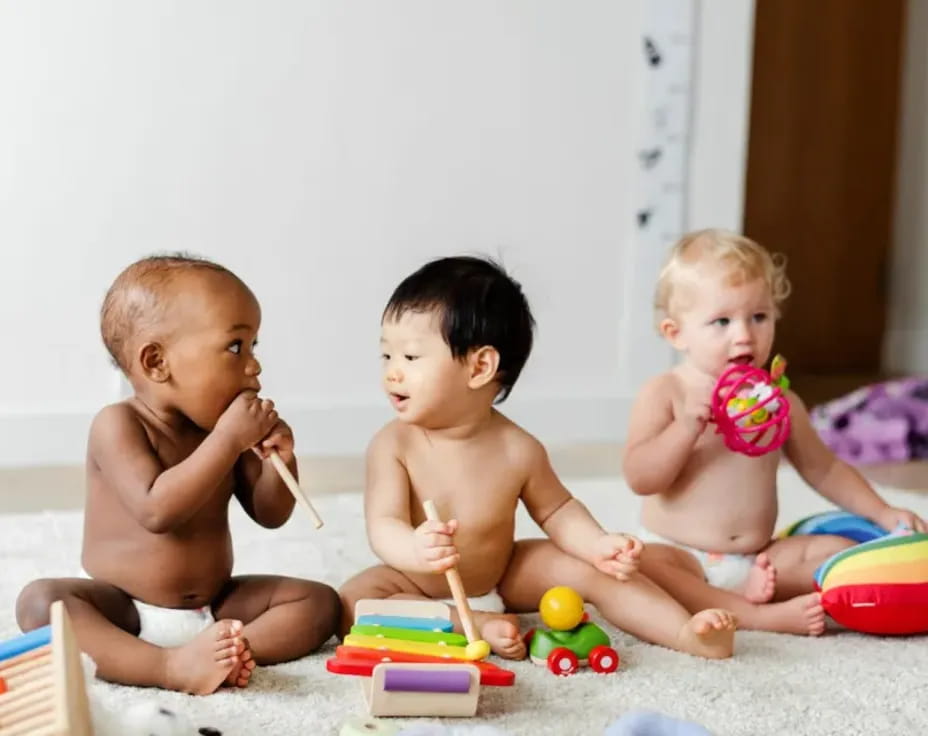 a group of babies playing with toys