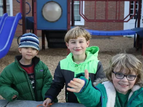 a group of children sitting at a table posing for the camera