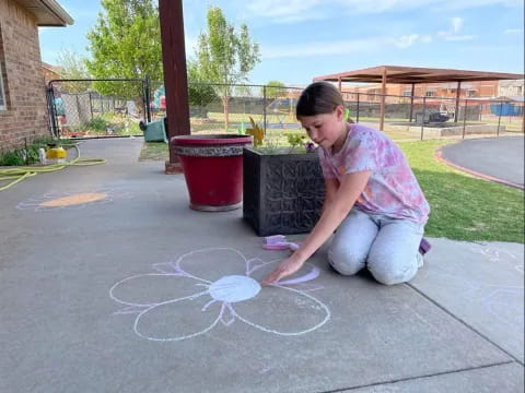 a girl drawing a circle on the ground