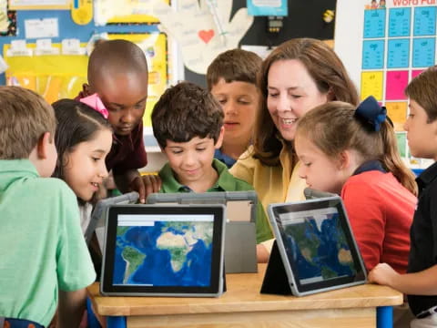 a group of children looking at a tablet