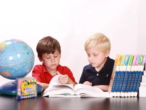 two boys reading a book