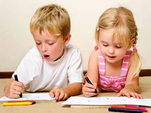 a couple of children writing on paper