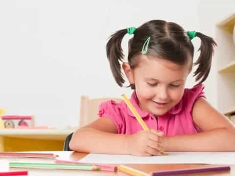 a girl coloring on a book