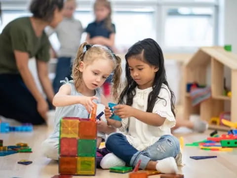 a couple of young girls playing with toys on the floor