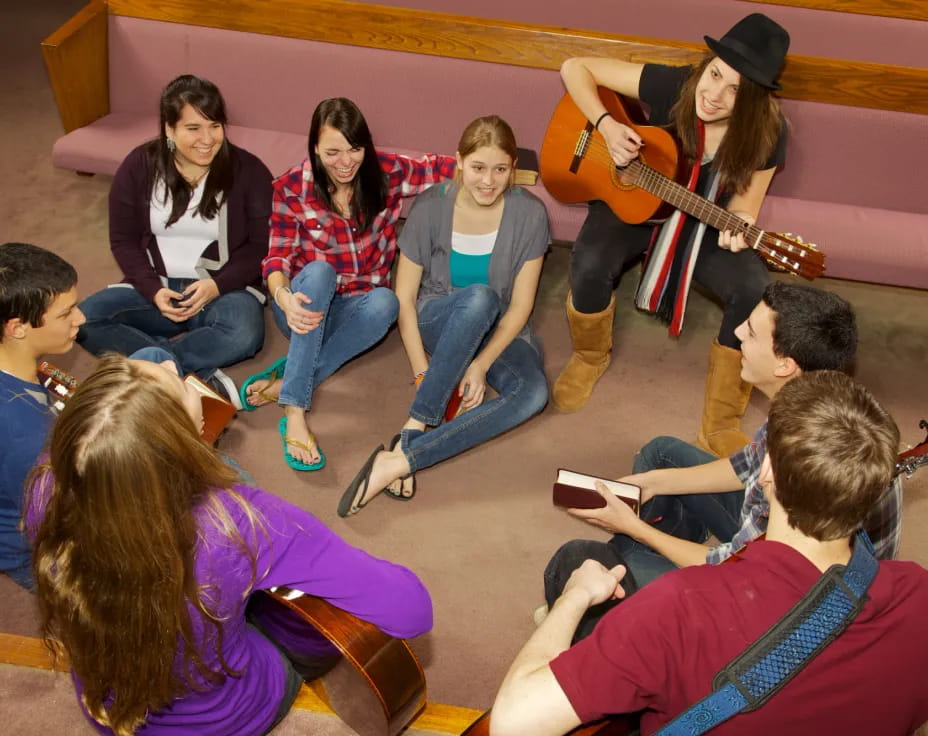 a group of people sitting on the floor playing instruments