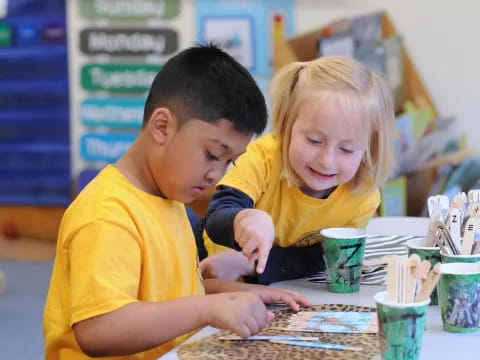 a boy and girl looking at a computer screen