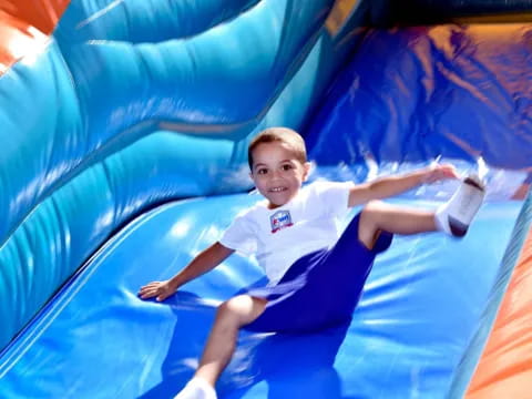 a boy lying on a large colorful slide